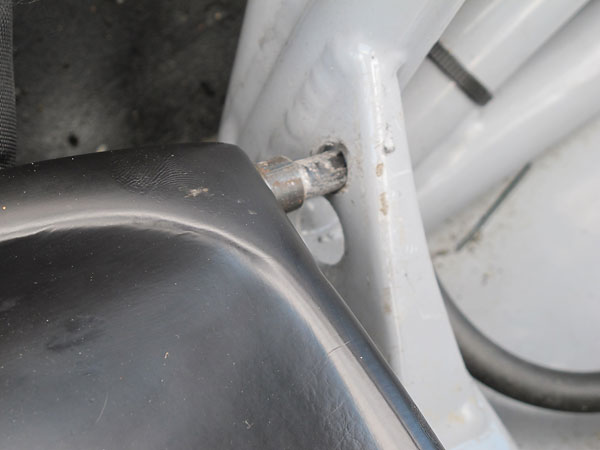 Two nibs on the front of the fiberglass seat plug into brackets on the frame.