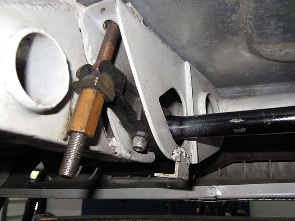 Attachment of driver's side torsion spring to a crossmember under the floorboard.