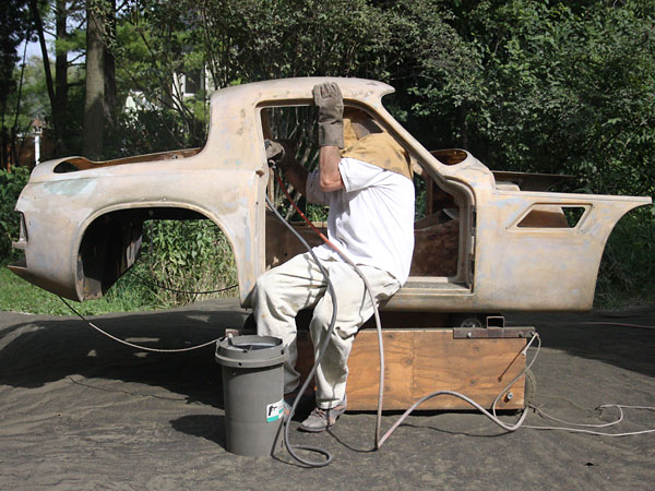 The first layer of old paint came off the fiberglass body with a razor blade.