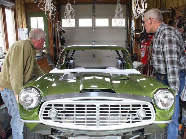 A friend helps with installation of the bonnet assembly.