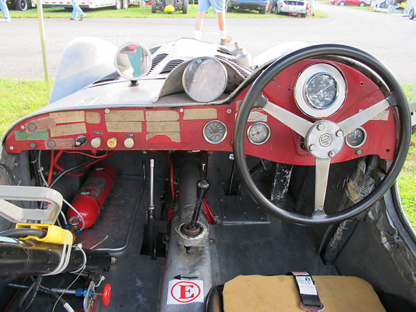 Lester MG KUR 4's wooden dashboard, with fourteen faded SCCA tech-inspection decals still attached.
