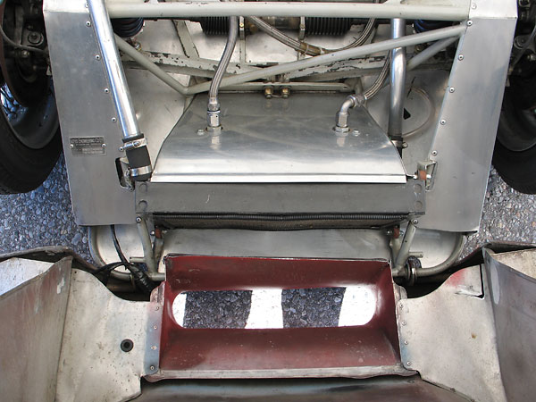 After passing through the radiator, airflow routes downward rather than through the engine compartment.