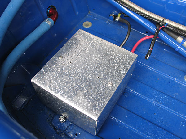 A lightweight AGM-type racing battery is mounted under this aluminum cover.