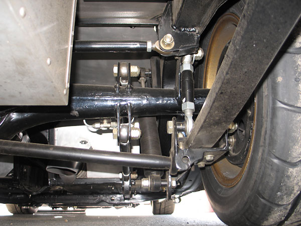Two vertical radius rods connected above the springs, rearward of the axle.