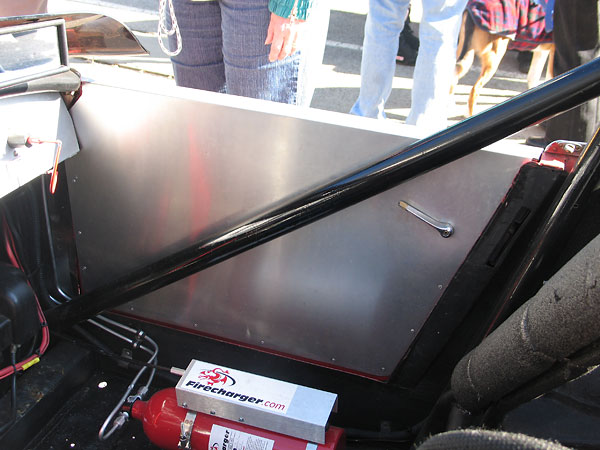 The roll hoop is supplemented with side bars and also a cross bar behind the aluminum dashboard.