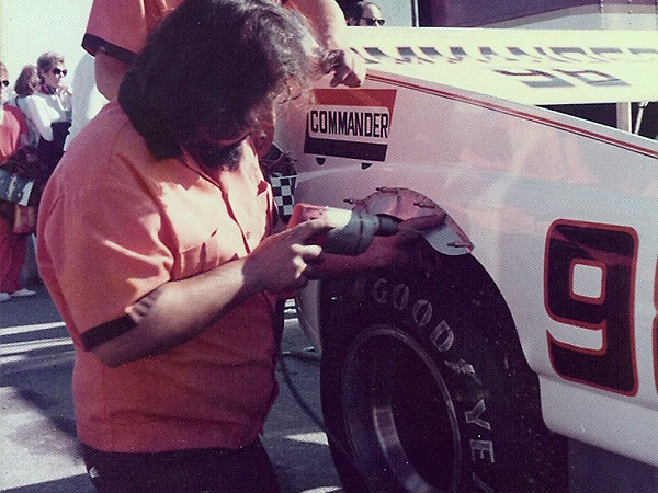 Bruce Robles is shown fitting the new fender flares in the Laguna Seca paddock.