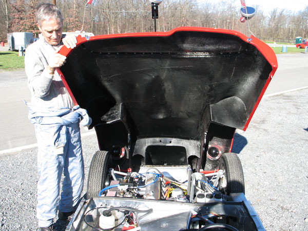 Tom holds open the bonnet of his Lola Sports Mark One race car.
